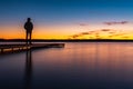 Sunset on the shore of the lake with a footbridge Royalty Free Stock Photo