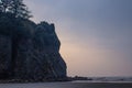 hazy evening with sun behind rock at beach Royalty Free Stock Photo