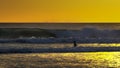 Sunset shot of a young surfer wading out to go surfing kuta, bali