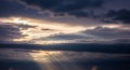 Dramatic Sunset Sky with Dark Clouds and Golden Sun Rays Breaking Through the Atmosphere Royalty Free Stock Photo