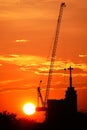 Sunset silhouette construction building tower crane cross on the roof of the church of the Sloane Royalty Free Stock Photo