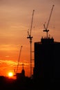 Sunset silhouette construction building tower crane cross on the roof of the church of the Sloane Royalty Free Stock Photo