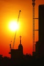 Sunset silhouette construction building tower crane cross on the roof of the church of the Sloane Royalty Free Stock Photo