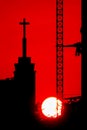 Sunset silhouette construction building tower crane cross on the roof of the church of the Sloane Royalty Free Stock Photo