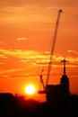 Sunset silhouette construction building tower crane cross on the roof of the church of the Sloane Royalty Free Stock Photo