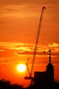 Sunset silhouette construction building tower crane cross on the roof of the church of the Sloane Royalty Free Stock Photo