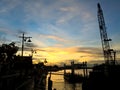 Sunset and silhouette of construction crane, harbor, river Royalty Free Stock Photo