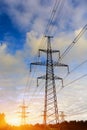 Sunset with a silhouette of electricity pylon and power lines Royalty Free Stock Photo