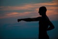 Sunset silhouette of man practicing martial arts