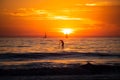 Sunset silhouette of paddle board on a sea. Relaxing on ocean. Sunrise over the sea and beautiful cloudscape. Colorful Royalty Free Stock Photo