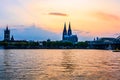 Sunset silhouette skyline landscape of the gothic Cologne Cathedra, Hohenzollern railway and pedestrian bridge, the old town and Royalty Free Stock Photo