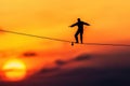Sunset silhouette of tightrope walker balancing on highwire Royalty Free Stock Photo