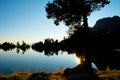 Sunset silhouette of trees and lake in natural enviornment, blue sky, reflections of landscape