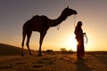 Sunset Silhouette of a woman and her camel. Royalty Free Stock Photo