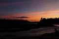 Sunset silhouettes of river bank in tropic