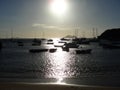 Sunset with silhuettes of fishing boats and schooners on the beach.