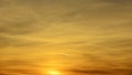 Sunset sky with clouds and contrails in the orange and yellow colors. Royalty Free Stock Photo
