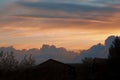Sunset sky with multicolor clouds. below you can see the roofs of houses