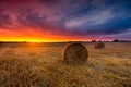 Sunset sky over field with straw bales