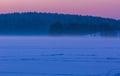 Sunset sky over frozen and snowy lake.