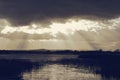 Sunset sky over a lake.Dark and dramatic scene, sun rays burst from the clouds