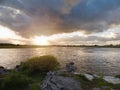 Sunset sky over a lake surface. River Corrib, Galway city, Ireland. Dark and dramatic scene. Sun flare and reflection in the water Royalty Free Stock Photo