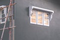 Sunset sky reflection on surface of glass window on gray cement wall of house during renovation work Royalty Free Stock Photo