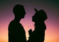 Sunset, sky and silhouette of couple with heart, emoji and light on romantic outdoor date. Love, man and woman with care Royalty Free Stock Photo