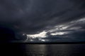 Sunset sky with sun rays and big cumulus clouds above a river. Royalty Free Stock Photo