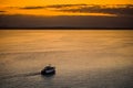Sunset with a small boat going in a big lake Royalty Free Stock Photo