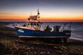 Before sunset small commercial fishing boat waiting to be launched from Hastings' beach.