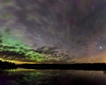 Sunset in a forest settingAurora, stars and clouds reflecting in a calm lake