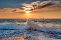 Sunset and splashing blue sea waves near the beach