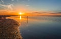 Sunset on stagnant river, sunset in calm lake with sandy coast, sun reflection on stagnant lake, stagnant water Royalty Free Stock Photo