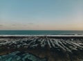 Sunset stone beach with clear blue water and shoreline