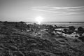 Sunset, stone beach with small and large rocks in black and white Royalty Free Stock Photo