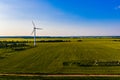 Sunset in summer countryside, aerial landscape. Renewable energy in rural area. Wind turbine concept Royalty Free Stock Photo