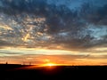 Sunset in the summer in the East of England. A layered gold and white sunset overlooking a nature reserve.