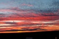 Sunset in the summer in the East of England. A layered gold, red and white sunset overlooking a nature reserve.