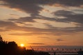 Sunset on a summer evening on the illuminated sky in pink and purple colors over the river against the background of the railway Royalty Free Stock Photo