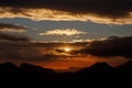 Sunset. The sun above the line of mountains Royalty Free Stock Photo