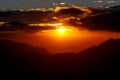 Sunset. The sun above the line of mountains Royalty Free Stock Photo