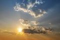 Sunset with sun and clouds on blue and orange dramatic sky with sun rays