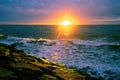 Sunset with sun flare over sea and rocks Royalty Free Stock Photo