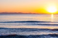 The sunset sun is going down behind the horizon. Tyrrhenian Sea bay with Elba island on the background at the sunset. Cala Violina Royalty Free Stock Photo