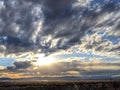 Sunset with sun rays coming through clouds and blue sky Royalty Free Stock Photo
