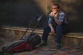 Sunset sun rays fall on face of a gardener man, landscaper with lawn mower, relaxing with cup of coffee in the backyard Royalty Free Stock Photo