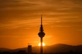 Sunset with the sun setting behind the mountains and over the base of a communications tower Royalty Free Stock Photo