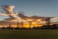 Sunset, sun setting behind trees countryside, grassland Royalty Free Stock Photo