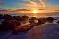 Sunset With Sunburst Over Rocky Seashore